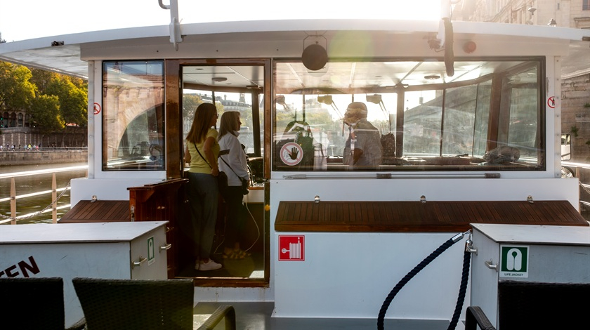 Deux visiteuses à l’entrée de la cabine de pilotage d’un bateau amarré sur la Seine.